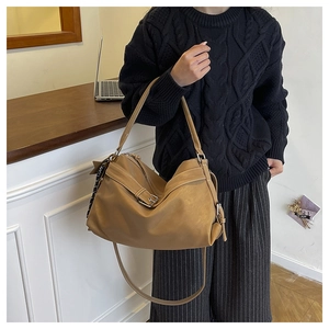 Detail of khaki large tote bag with metallic buckle and stylish polka dot silk scarf detail