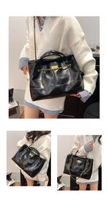 Detail of black quilted tote bag with gold chain strap and turn-lock closure system