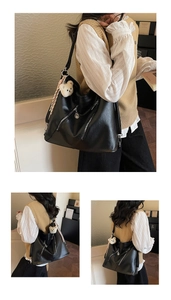 Detail view of large black tote bag with decorative zippers and plush bear keychain charm