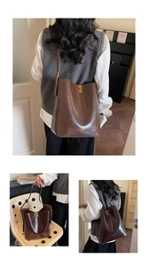 Detail of dark brown leather bucket bag with gold twist lock and fine retro texture