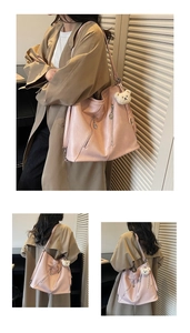Detail of pink hobo tote bag featuring diagonal zippers and a cute plush bear charm
