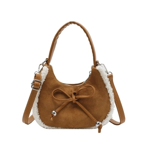 Braune matte Tasche in Halbmondform mit weißem Plüschbesatz und Schleife auf weißem Grund