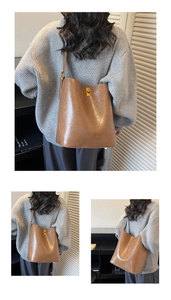Detail of vintage brown oil wax leather bucket bag with elegant gold twist lock buckle