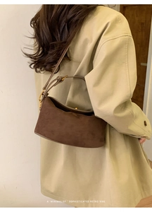 Détail d'un sac à main en daim marron vintage avec fermoir sphérique doré élégant