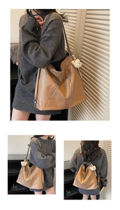 Detail view of camel leather tote bag with functional zippers and plush bear charm