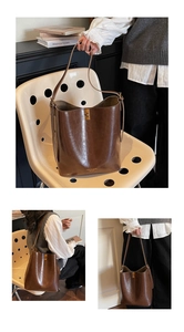 Close-up of brown vintage bucket bag featuring a gold metal clasp and premium leather texture