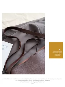 Detail of soft lychee grain leather shoulder strap on dark brown bucket tote bag