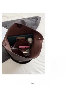 Spacious interior of a brown lychee pattern bucket bag holding a tablet and umbrella