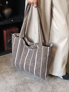 Brown and white vertical striped canvas tote bag with thick woven fabric and bow detail