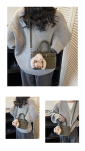 Détail du sac à main vert foncé avec un charme lapin blanc duveteux et une finition texturée