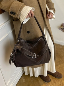 Brown suede tote bag with contrast stitching and star charm shown by a model