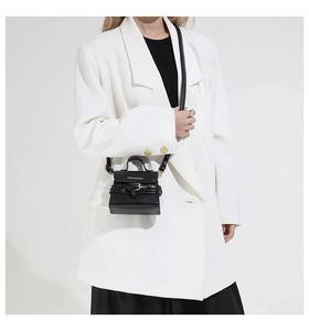 Fashionable black matte mini square bag with gold hardware shown on a model