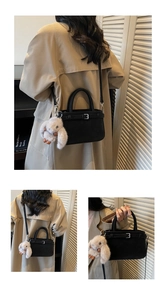 Détail du sac à main noir au fini mat avec un joli pendentif de lapin en peluche beige
