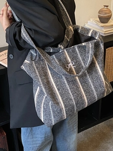 Grey vertical stripe cotton tote bag with a white bow accent and spacious interior