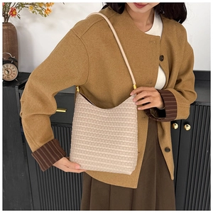 Beige woven texture hobo shoulder bag with leather strap shown in a stylish home setting