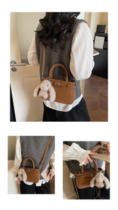 Détail d'un sac seau vintage marron avec boucle décorative et charm de lapin en peluche