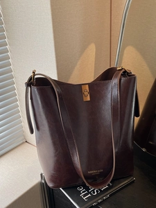 Retro dark brown leather bucket bag with gold hardware and stylish crossbody strap