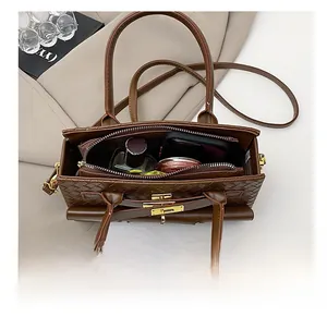 Vue intérieure du sac à main marron tressé montrant les compartiments de rangement