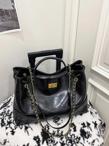 Classic black quilted leather tote bag with gold metal clasp and chain shoulder strap