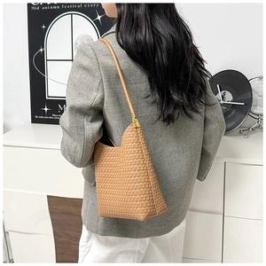 Brown woven leather hobo bag styled with a minimalist gray suit for commuting look