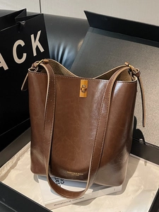Vintage brown leather bucket bag with gold turn-lock closure in premium gift box setting