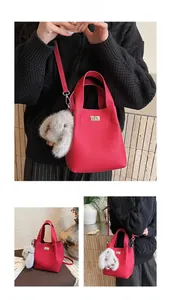 Detailed views of a red lychee pattern bucket bag with a cute rabbit charm accessory
