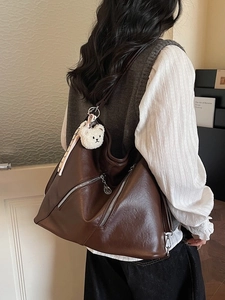 Brown PU leather tote bag with teddy charm shown from a side-rear angle on a model
