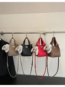 Detail view of four leather bucket bags with silver twist locks and plush rabbit charms