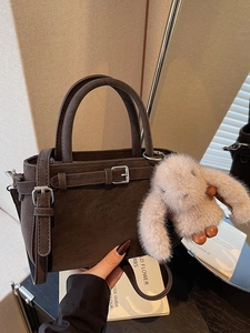Retro dark brown suede bucket bag with plush rabbit charm and elegant shoulder strap