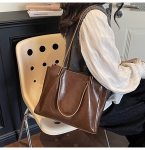 Deep brown oil wax leather tote bag shown on a chair in a retro vintage lifestyle setting