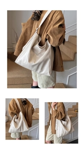 Detail of a large cream hobo bag with soft leather texture and wide shoulder strap