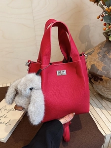 Magenta lychee grain bucket bag with a plush rabbit pendant and silver twist lock