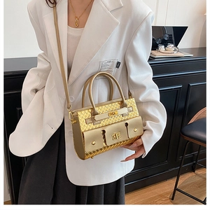 Modèle avec sac à main tressé doré doté de trois poches à fermoir et d'une bandoulière