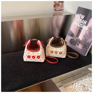 Detail van de mini polkadot handtas met 3D-bloemaccenten in rood en bruin