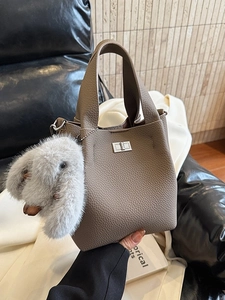 Chic grey litchi leather bucket bag with silver lock and plush rabbit charm
