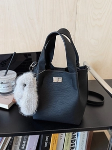 Litchi pattern leather bucket bag in black with silver twist lock and plush charm