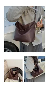 Close-up of brown litchi pattern leather texture and minimalist design on tote bag
