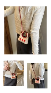 Detail van een mini crème crossbody tas met rode stippen en 3D bloemaccenten