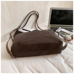 Close-up of a vintage dark brown tote bag with contrast stitching and matte finish leather
