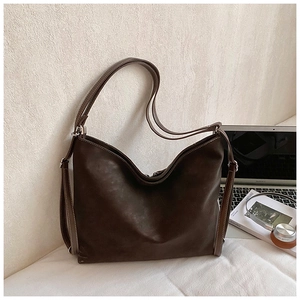 Detail view of large brown retro leather tote bag with white contrast stitching accents