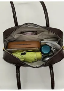 Spacious interior of dark brown leather shoulder bag showing umbrella and phone storage