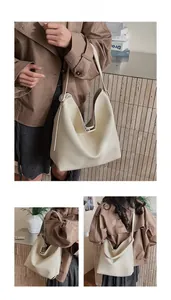 Detail view of cream-colored large tote bag with textured lychee grain leather finish