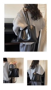 Detail view of large black tote bag in glossy faux leather with long shoulder straps