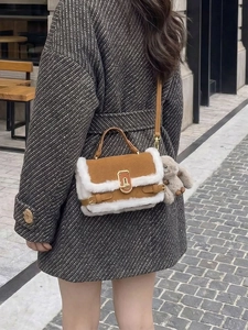 Dettaglio borsa a tracolla in pelle scamosciata con finiture in shearling e charm