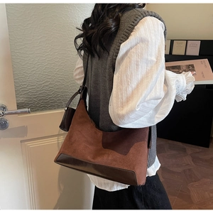 Detail of hobo bag with vintage suede texture and smooth leather patchwork for winter style