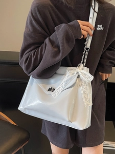 Stylish light blue glossy tote bag with white lace bow and silver twist lock on shoulder