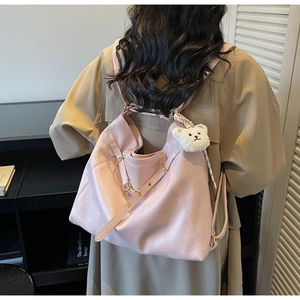 Detail of light pink tote backpack with adjustable straps and plush bear charm