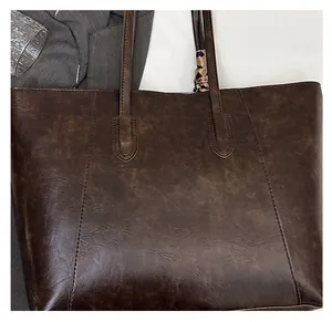 Detail of dark brown faux leather tote with vintage texture and leopard silk scarf
