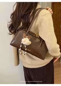Detail of retro brown PU leather shoulder bag with plush bear charm and beaded chain
