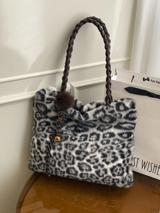 Large leopard print plush tote bag with woven handles and decorative fur balls